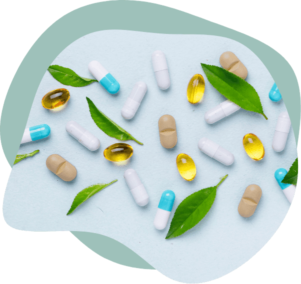 Different kinds of pills – solid, gel, capsules – are set aesthetically on a brightly colored tabletop dispersed with small fresh herb leaves, Next Level Nutrition Supplements